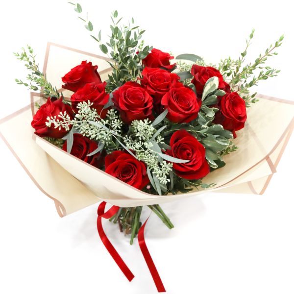 Bouquet of red roses wrapped in cream paper with a red ribbon