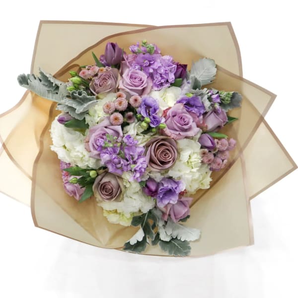 Bouquet of lavender and white flowers wrapped in tan paper