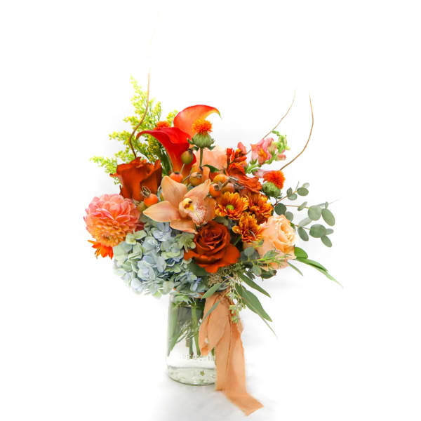 Orange and peach mixed bouquet in a glass vase