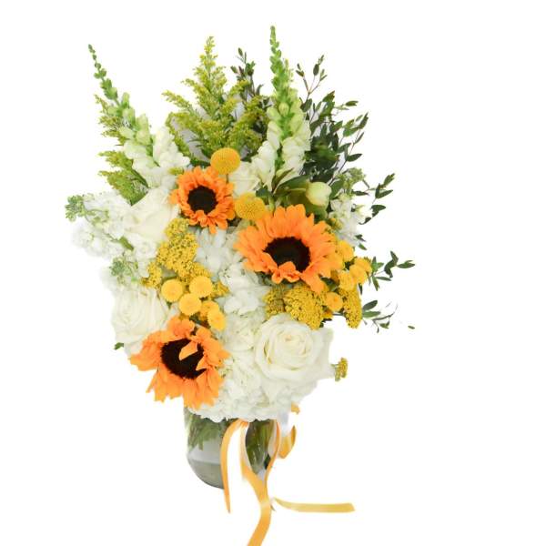 Bouquet of white flowers with orange sunflowers in a glass vase