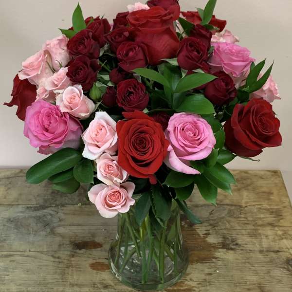 Bouquet of red and pink roses in a clear glass vase