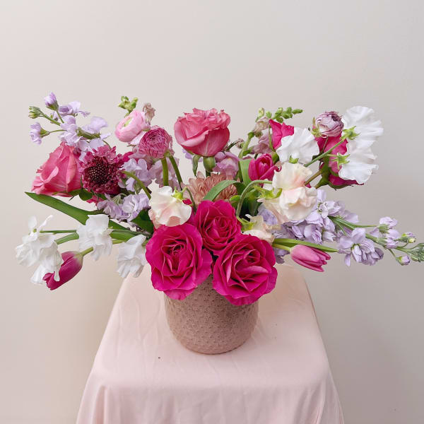 Pink and lavender flower arrangement in a textured vase