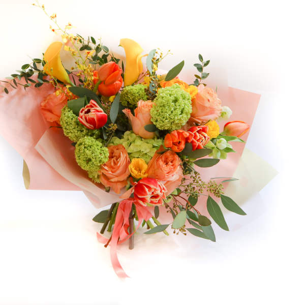 Bouquet of orange and yellow flowers wrapped in pink paper