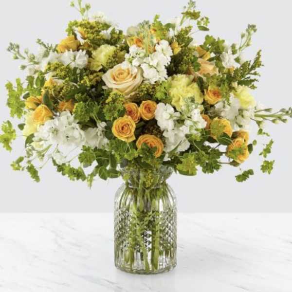 Yellow and white mixed flower bouquet in a glass vase