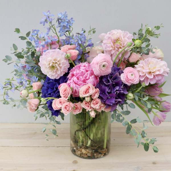 Pink and purple mixed flower arrangement in a glass vase