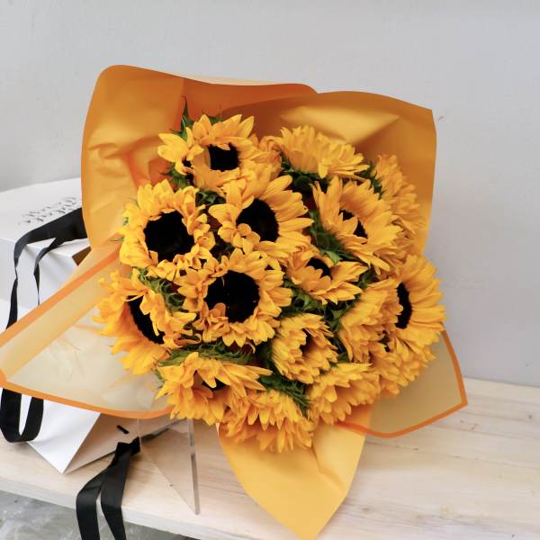 Bouquet of yellow sunflowers wrapped in orange paper