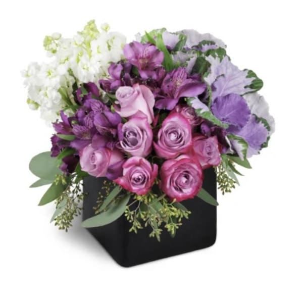 Pink and purple roses arranged in a black square vase