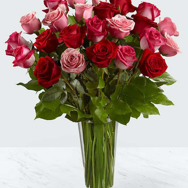 Bouquet of red and pink roses in a clear glass vase
