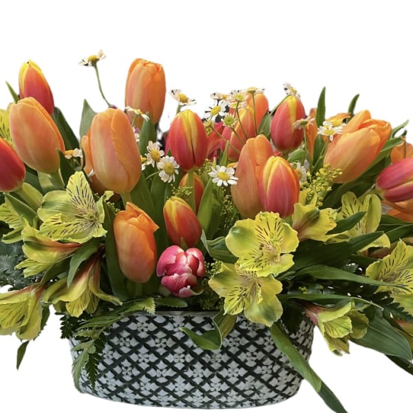 Basket of orange tulips and yellow flowers with greenery