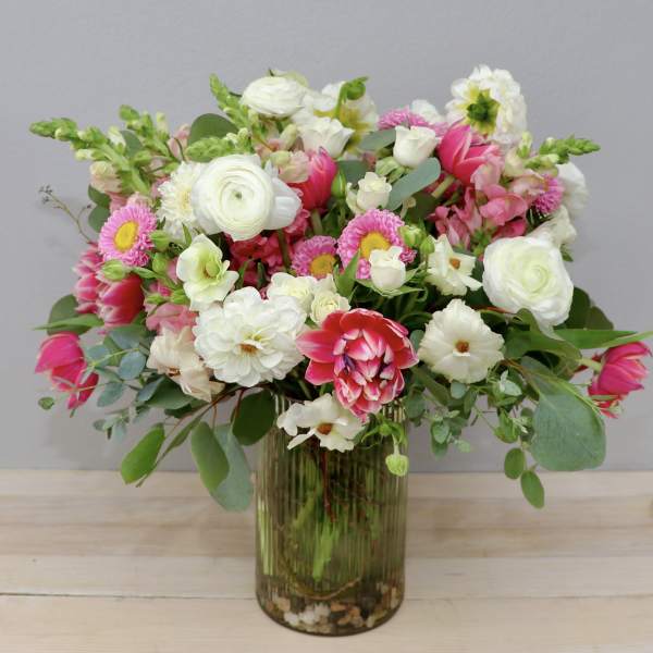 Mixed pink and white flowers arranged in a glass vase
