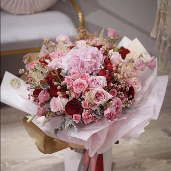 Pink and red rose bouquet wrapped in pale paper