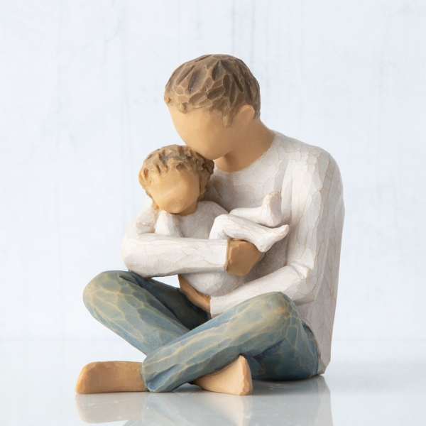 Wooden figurine of a seated adult holding a child