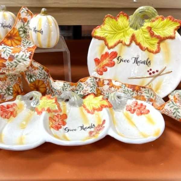 Decorative pumpkin-shaped plates and autumn ribbon with "Give Thanks" text