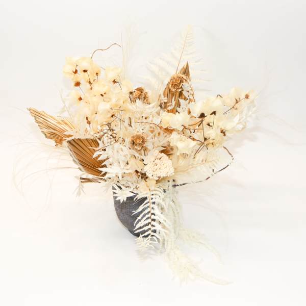 Cream dried floral arrangement in a dark vase