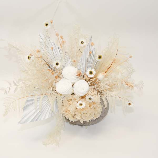 Cream-colored floral arrangement with white blooms and dried accents