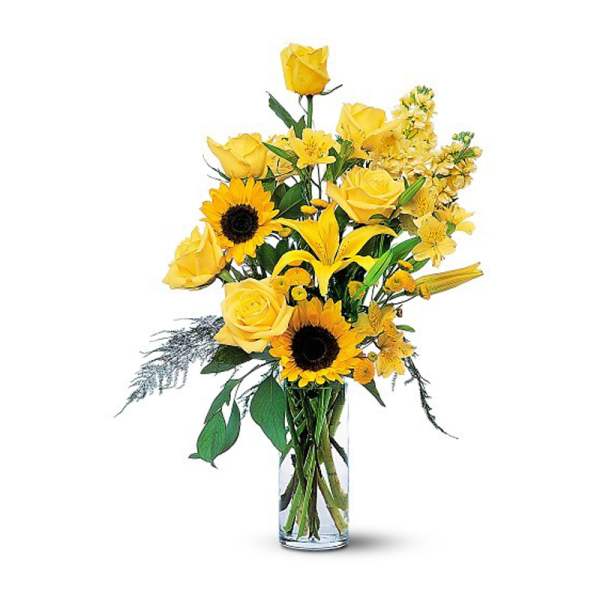 Yellow roses and sunflowers in a clear glass vase
