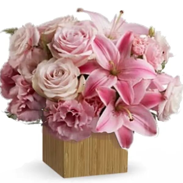 Pink roses and lilies arranged in a square wooden vase