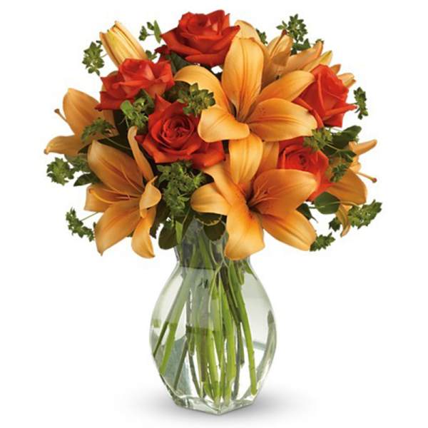 Bouquet of orange lilies and red roses in a clear glass vase