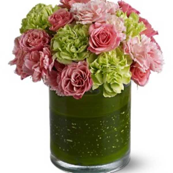 Pink and green flower arrangement in a green glass vase