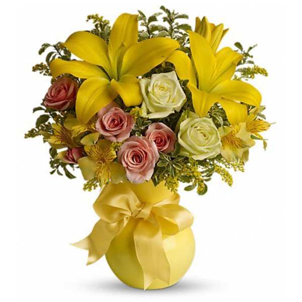 Yellow lilies and pink roses in a gold vase with a ribbon bow