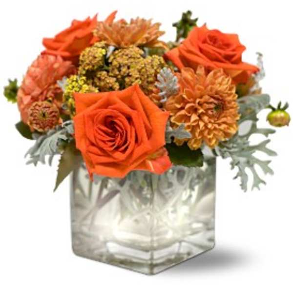 Orange roses and mums in a clear square vase