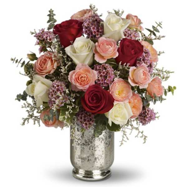 Bouquet of red, white, and peach roses in a silver vase