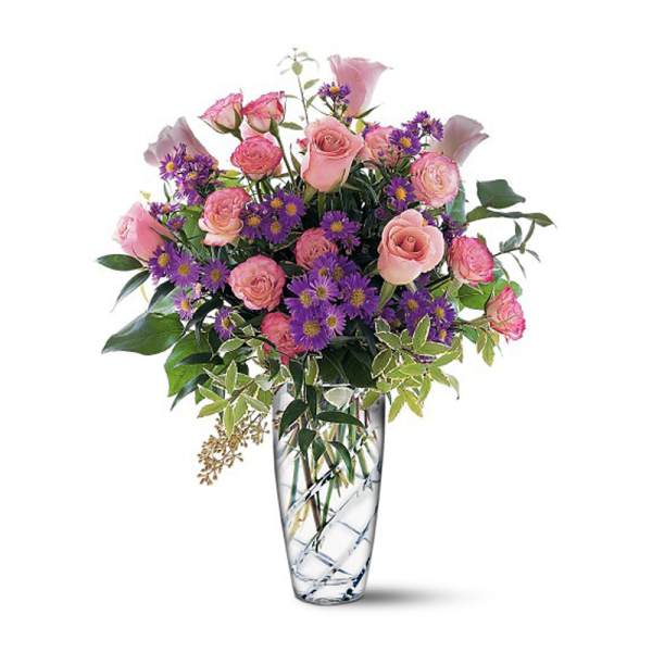 Pink roses and purple daisies in a clear glass vase