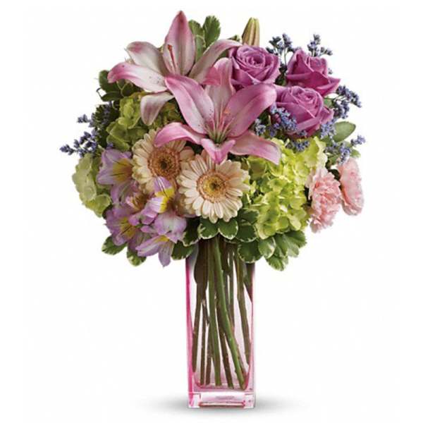 Pink lilies, roses, and daisies in a clear glass vase