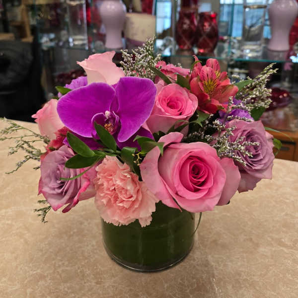Pink and purple flower arrangement in a glass vase