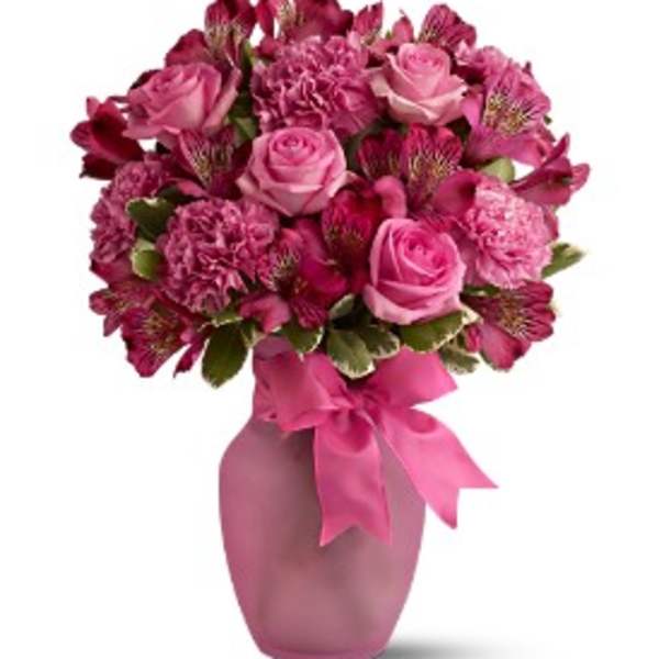 Pink rose and carnation bouquet in a pink vase with ribbon