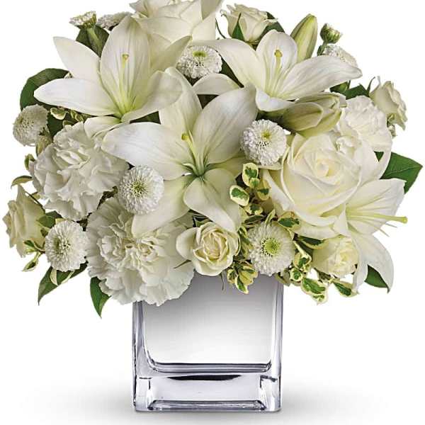 White lilies and roses arranged in a clear glass vase