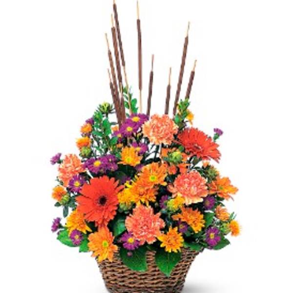 Tall basket arrangement of orange and yellow flowers with purple accents and cattail reeds.