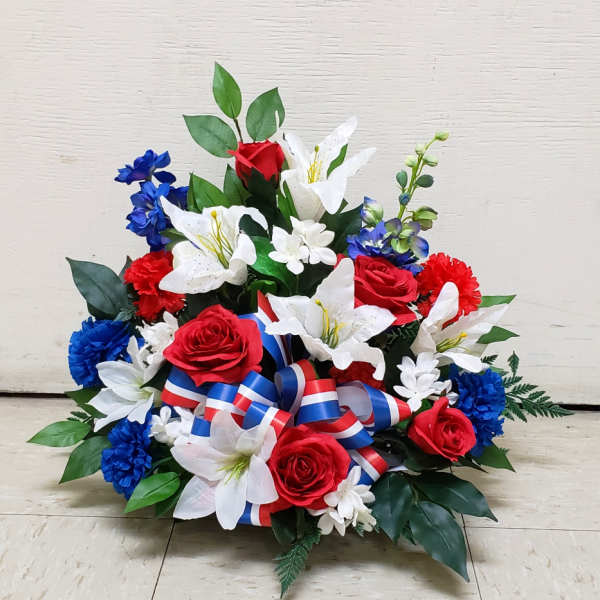 Red, white, and blue silk arrangement with roses, lilies, and carnations with patriotic ribbon in a low container