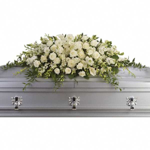 White rose and lily casket spray arranged on a silver casket