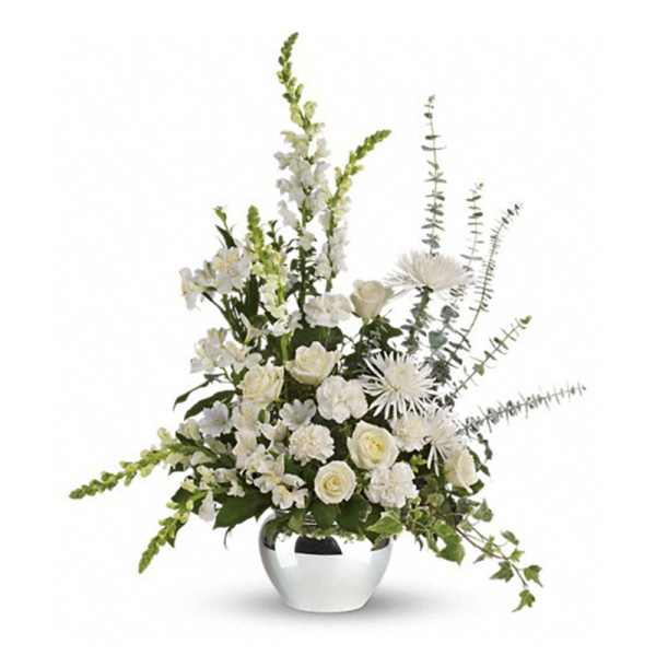 Tall white flower arrangement with roses, mums, and snapdragons in a round silver vase