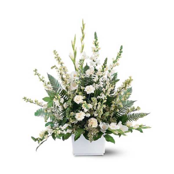 Tall white floral arrangement with carnations and spikes of white blooms in a white rectangular vase.
