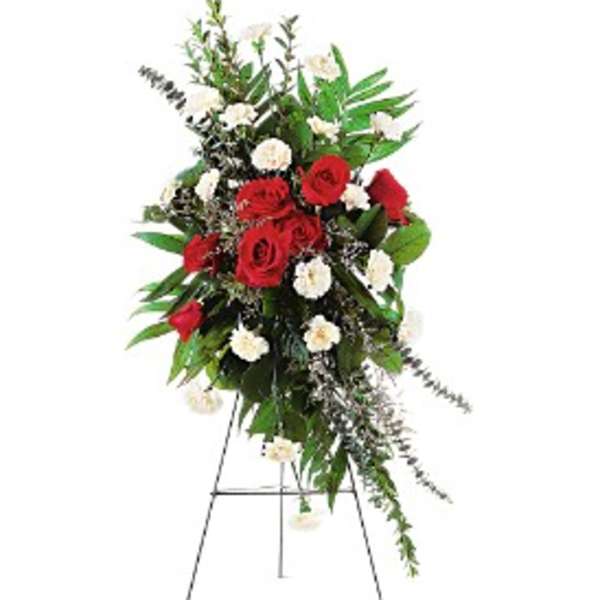 Tall standing spray of red roses and white carnations on a metal easel