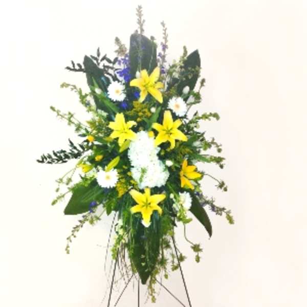 Standing spray of yellow lilies, white daisies, and white mums on a metal easel