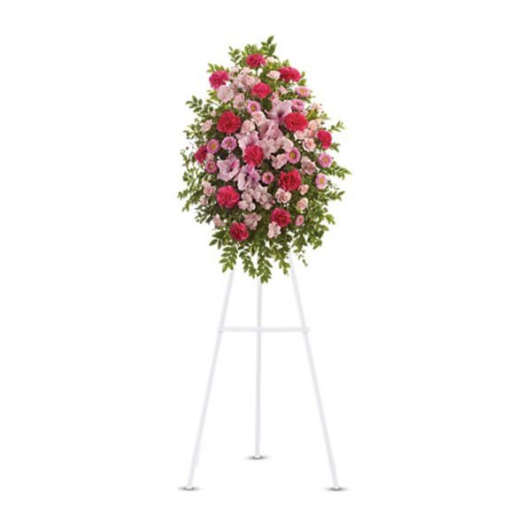 Tall pink and red standing spray on a white easel with an oval shape
