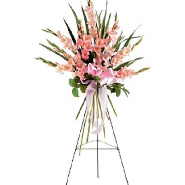 Tall pink standing spray with clustered blooms and ribbon bow on a metal easel.