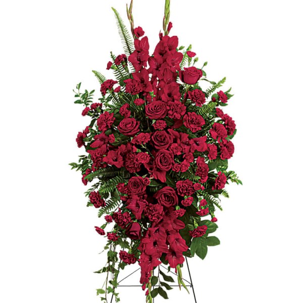 Tall standing spray of red roses and carnations with greenery on a metal easel