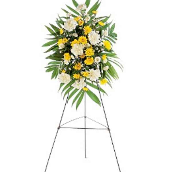 Standing spray of white carnations and yellow daisies on a metal easel.