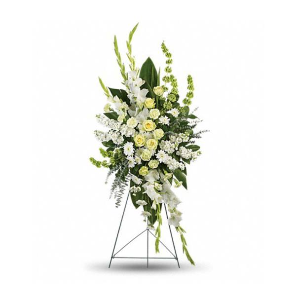 Tall white and pale yellow funeral spray on a standing easel
