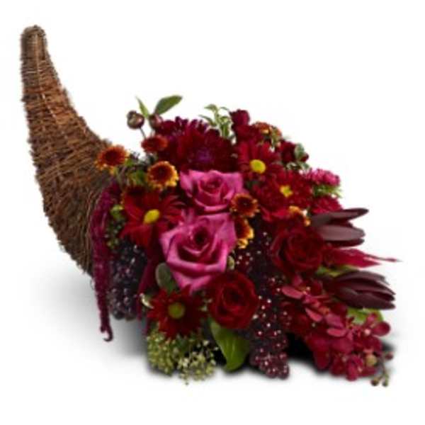 Red and burgundy floral cornucopia arrangement in a wicker horn basket