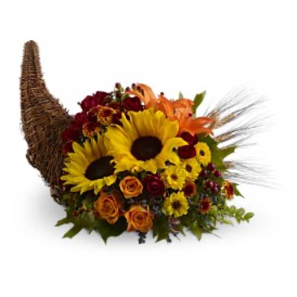 Autumn cornucopia of sunflowers, orange lilies, and roses in a woven horn-shaped basket