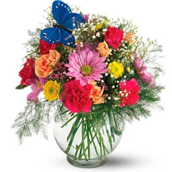 Colorful mixed bouquet in a clear glass vase with a blue butterfly decoration