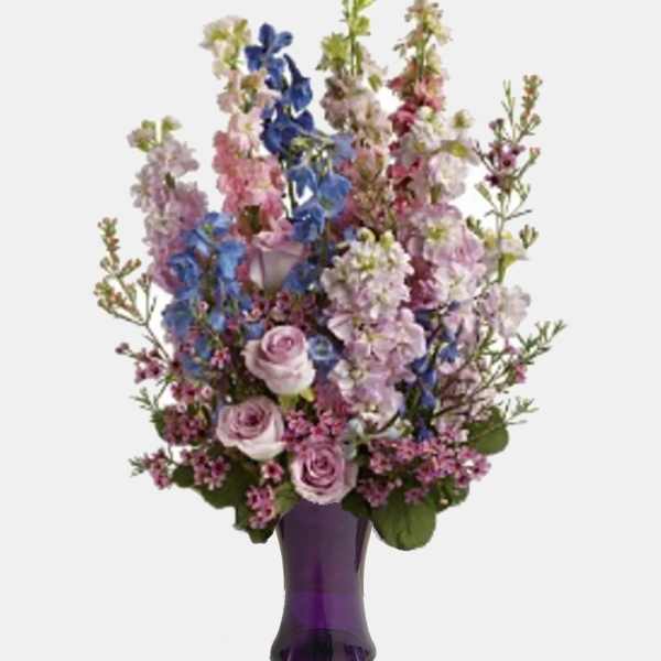 Lavender roses and blue-purple flowers in a purple vase