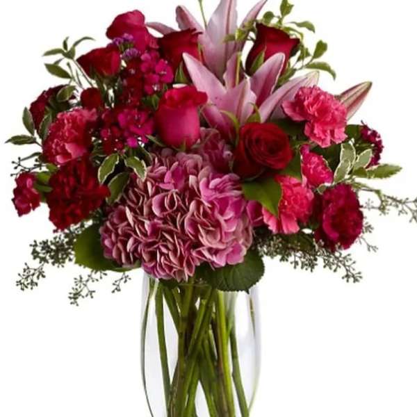 Bouquet of pink and red flowers in a clear glass vase