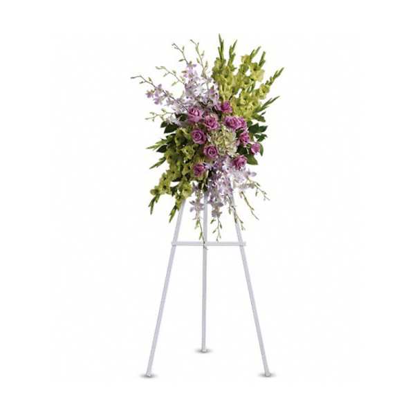 Tall standing spray of green and lavender flowers arranged on a white metal easel.