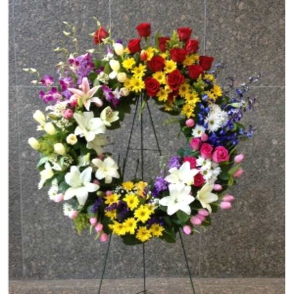 Large multicolor standing wreath of mixed flowers on a metal easel